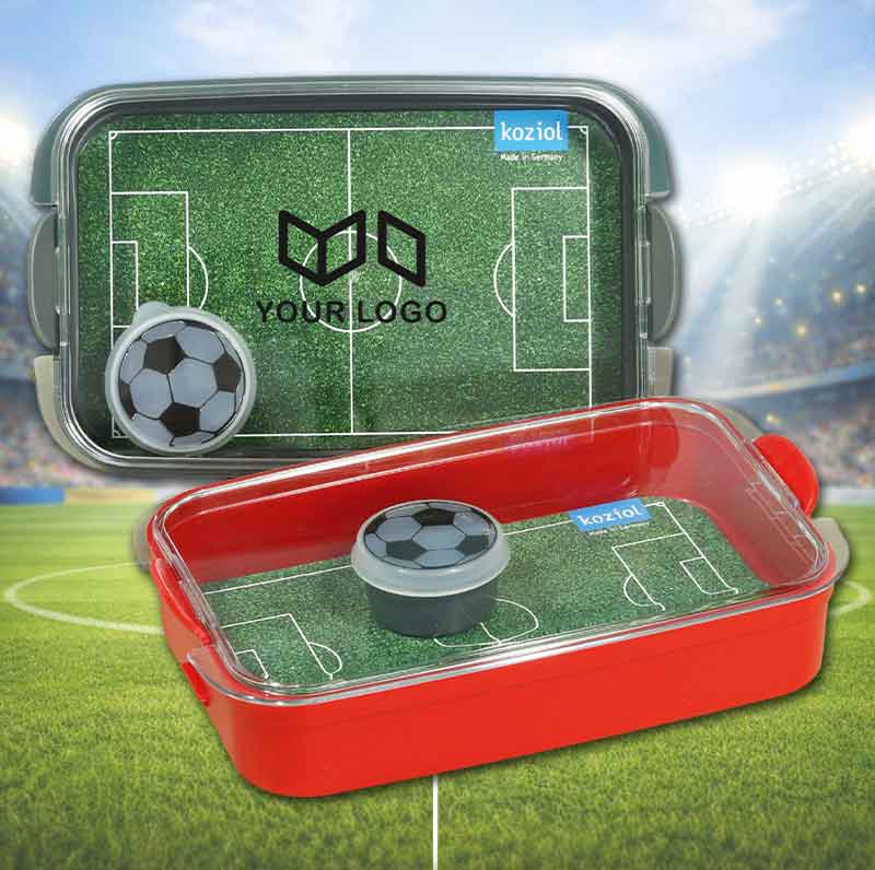 Eine graue und rote Bentobox mit Fußballfeldeinleger und kleinen Dipschale im Fußball-Look